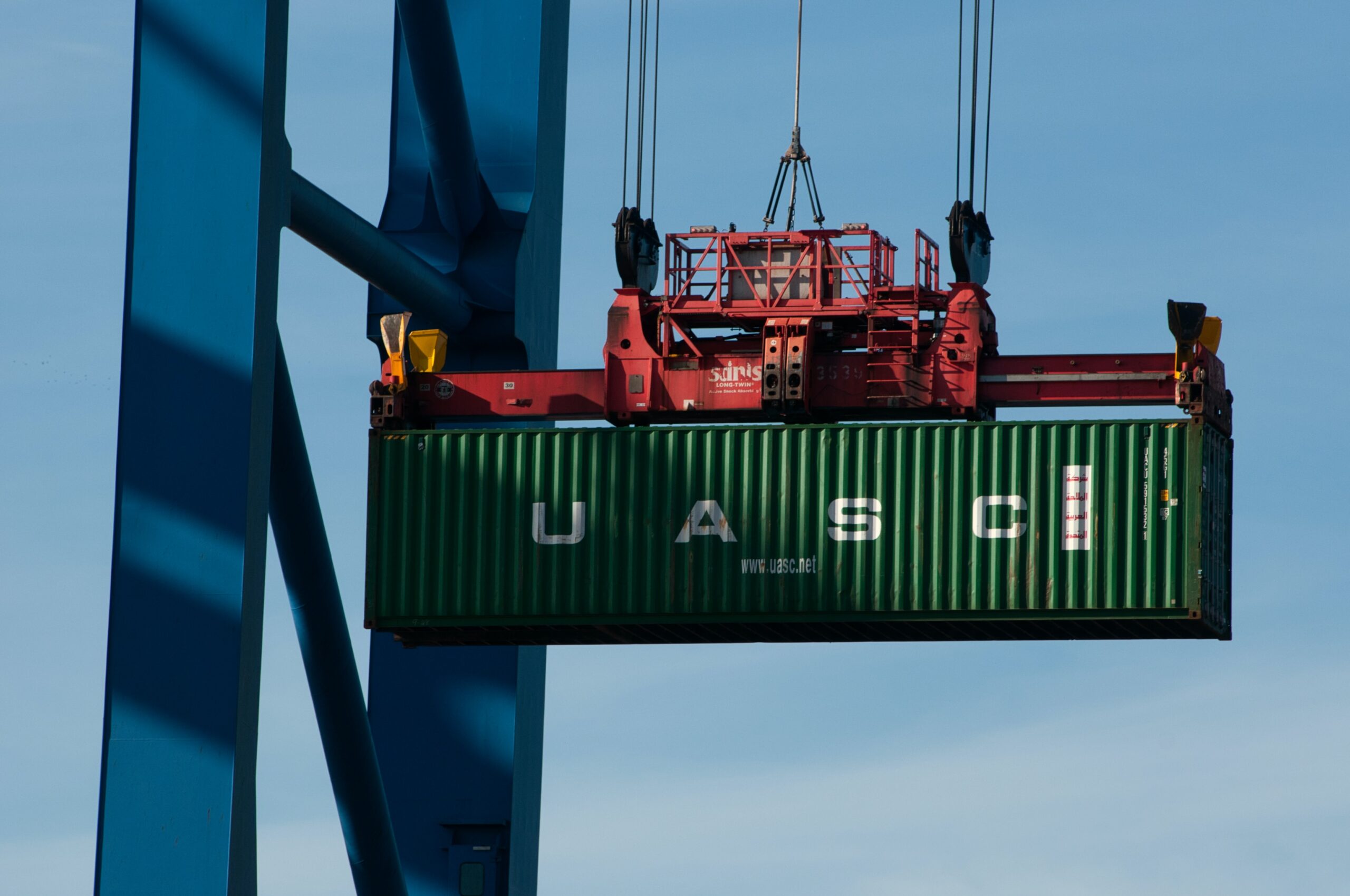 alt="crane loading container on ship"